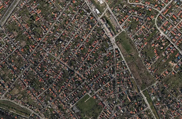 Aerial photo of a suburban area with red roofed family houses and green spaces