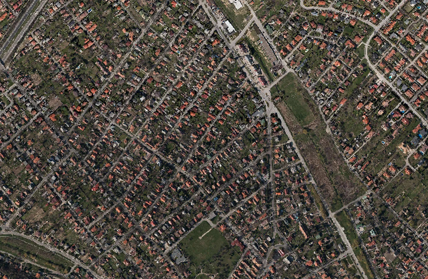 Aerial photo of a suburban area with red roofed family houses and green spaces